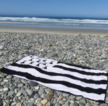 Badehandtuch Gwenn ha Du in Schwarz-Weiß am Strand ausgebreitet